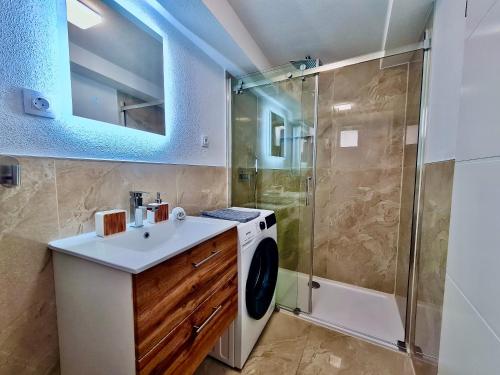 a bathroom with a washing machine and a shower at Mini Lea in Jadranovo