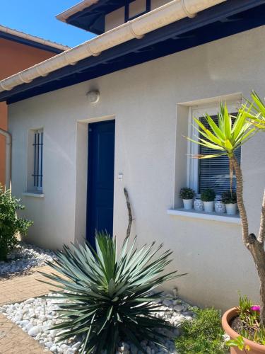 a house with a blue door and some plants at Domaine du Malda Côte Basque in Anglet