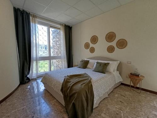 a bedroom with a bed and a large window at Home among the olive trees in Tivoli