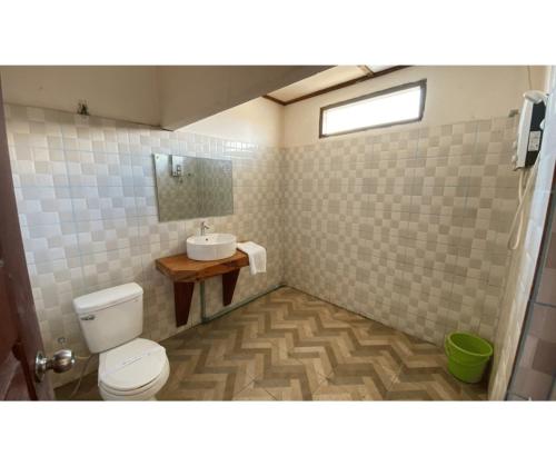 a bathroom with a toilet and a sink at Johnny Guesthoues and Restaurant in Ban Donsôm Tai