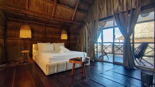 a bedroom with a bed and a large window at Hotel Boutique Sylvie in Mahahual