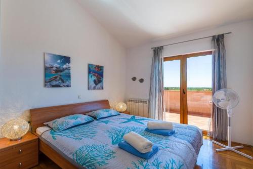 a bedroom with a bed with blue pillows on it at Villa Antonela in Divšići