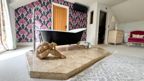 a bathroom with a bath tub and a teddy bear at Gorse Lodge Lakeside & Courtyard in Stubton