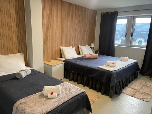 a hotel room with two beds and a window at Liber Guest House in Braga