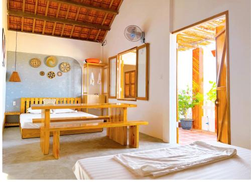 a bedroom with two beds and a table and a mirror at Blue Sea Homestay 2 in Phu Yen