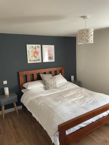 a bedroom with a large white bed with two tables at Milk Shed in Chard