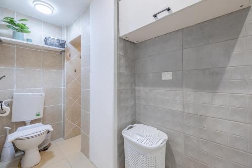 a bathroom with a white toilet and a shower at Masada34a City Center in Haifa
