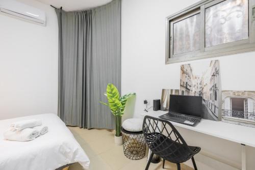 a bedroom with a desk with a computer and a chair at Masada34a City Center in Haifa