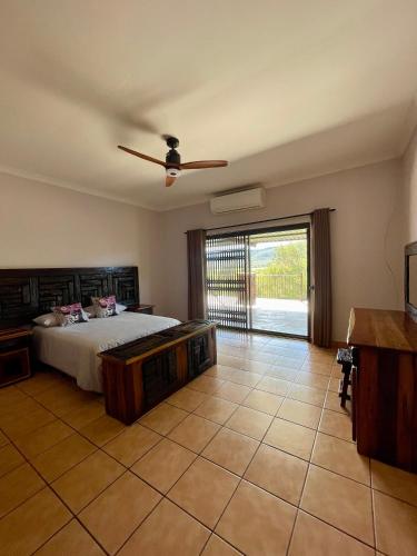 a bedroom with a bed and a sliding glass door at Emmanuel Guest Villa in Thabazimbi