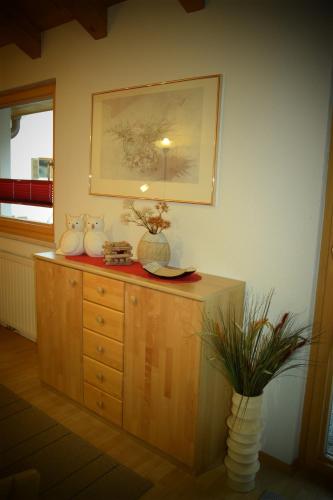 a room with a wooden dresser with vases on it at Apart Dominika in Ried im Oberinntal