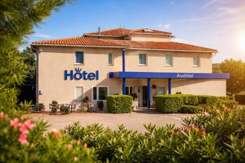 a hotel with a sign on the side of a building at Audotel in Carcassonne