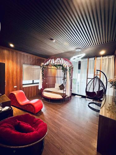a room with a room with a swing and chairs at Hotel Red River in Hà Ðông