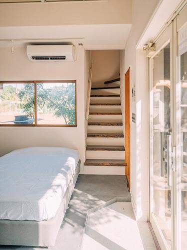 a bedroom with a bed and a stair case at AJITO Chigasaki in Chigasaki
