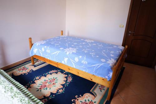 a bed with a blue cover on top of a rug at Apartment Simon - Berat City Center in Berat