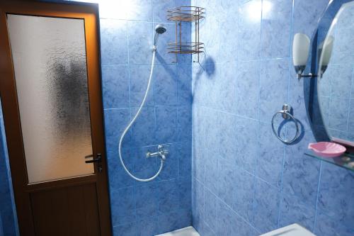 a bathroom with a shower with a phone on the wall at Apartment Simon - Berat City Center in Berat