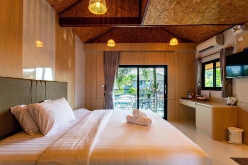 a bedroom with a large bed with a hat on it at Neenlawat Riverside in Suratthani