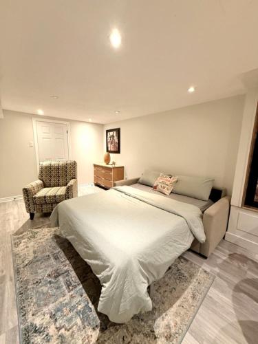 a bedroom with a large bed and a chair at Large Private Suit With Free Parking in Mississauga