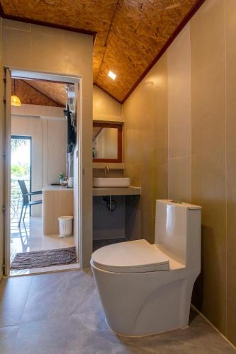a bathroom with a toilet and a kitchen at Neenlawat Riverside in Suratthani