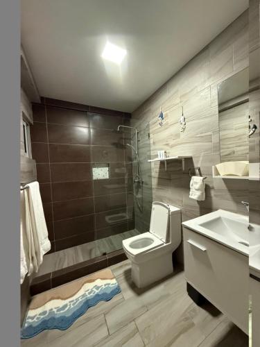 a bathroom with a toilet and a sink and a shower at City Oasis in Santo Domingo