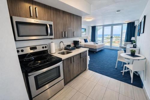 a kitchen with a stove and a living room at Relaxing Ocean View Condo by the Beach in San Juan