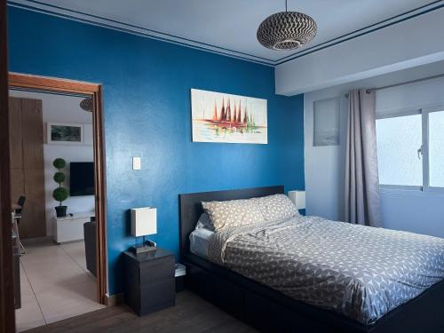 a bedroom with blue walls and a bed in it at City Oasis in Santo Domingo