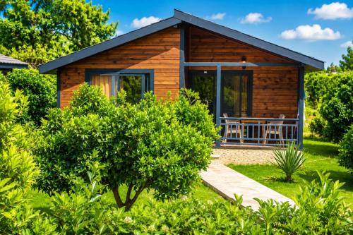 a wooden cabin with a porch in a garden at Çıralı Villa 2 in Kemer