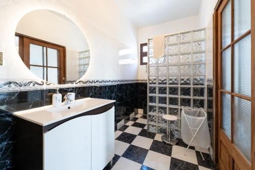 a bathroom with a sink and a black and white checkered floor at Sailor House - By Wehost in Porto Santo