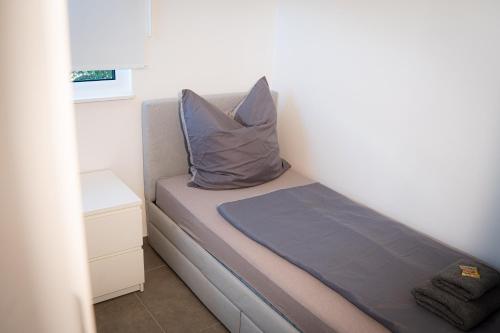 a small bedroom with a bed with a pillow on it at Black Wood Tiny House in Mendig - Eifel Escape in Mendig