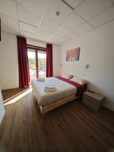 ein Schlafzimmer mit einem großen Bett und roten Vorhängen in der Unterkunft Bed&Harmony in Colleferro