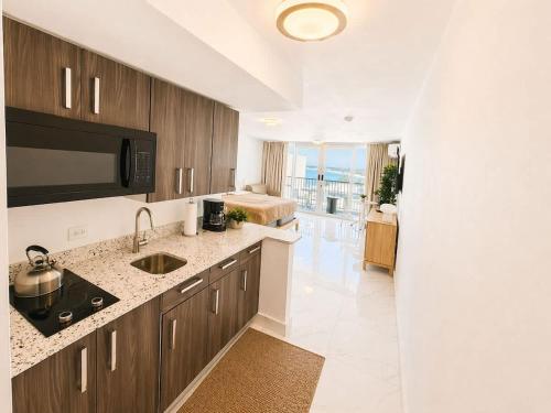 a kitchen with a sink and a microwave at Oceanview Beach Condo in Prime Location in San Juan