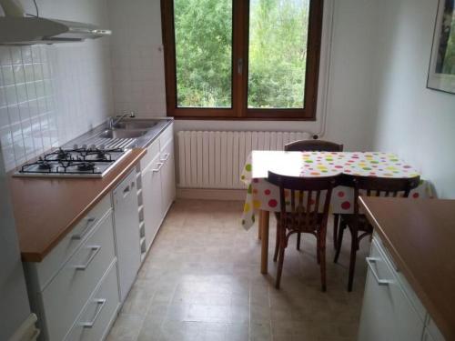 a kitchen with a stove and a table with chairs at Apartment mit Gemeinschaftspool im Diois by Interhome in Die