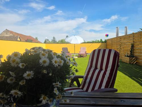 a patio with a chair and flowers in a yard at Hawa's Penthouse Studio with Terrace in Eferding