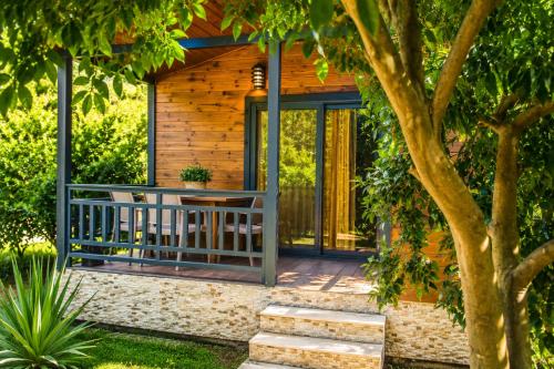 a wooden cabin with a table and a tree at Çıralı Villa 2 in Kemer