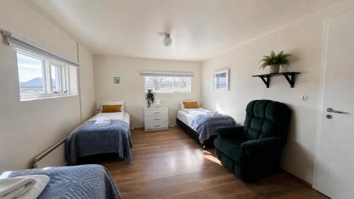 a room with two beds and a couch and a chair at Thorbrandsstadir Farm Holidays in Þorbrandsstaðir