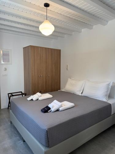 a bedroom with a large bed with towels on it at Green Dream Tinos in Tinos
