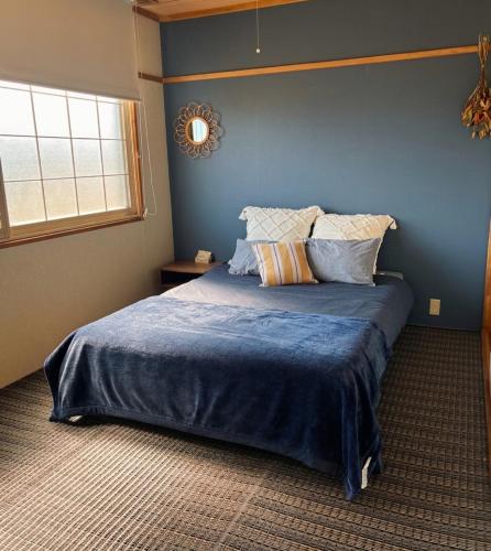 a bedroom with a large bed with blue walls at Olive retreat Sapporo 札幌市南区 一軒家の1フロア貸切 5名まで 2ベッドルーム 無料駐車場 登山 スキー場への好アクセス in Sapporo