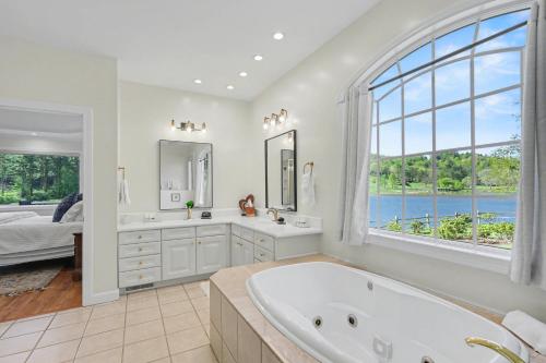 a large bathroom with a tub and a large window at Chic Sky Valley Resort Home on Golf Course! in Sky Valley