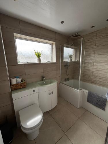 a bathroom with a toilet and a tub and a sink at Caol Mountain View in Caol