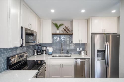 a kitchen with white cabinets and a stainless steel refrigerator at 103 Kihei Holiday in Kihei