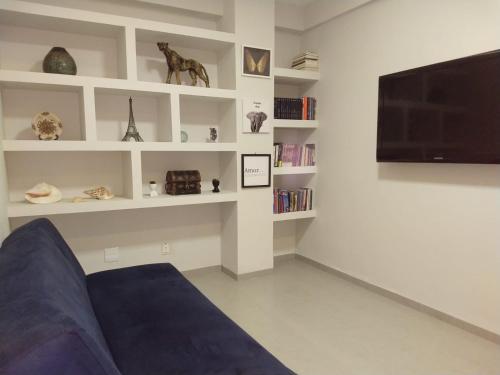 a living room with a couch and a flat screen tv at Izze Home in Palmas