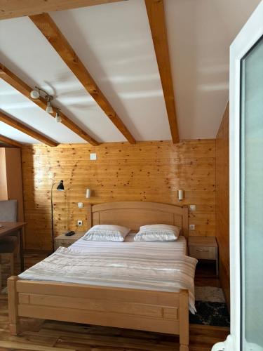 a bedroom with a bed in a room with wooden walls at Apartments Grbović in Žabljak