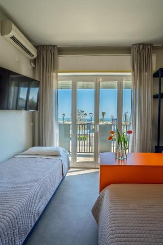 a bedroom with two beds and a view of the ocean at Fantini Club Hotel in Cervia