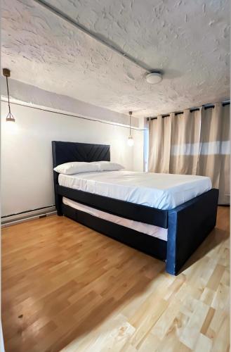 a large bed in a room with a wooden floor at Apartamento Barranquero Centro in Quimbaya