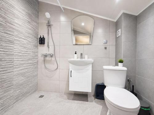 a bathroom with a toilet and a sink and a shower at Paradise View Rooms in Shkorpilovtsi
