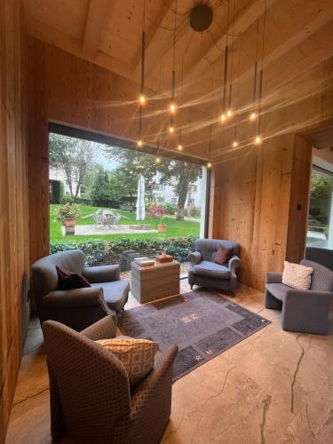 a living room with furniture and a large window at Hotel alle Rose Family inspired garden and SPA in Cavedago