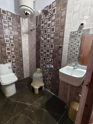 a bathroom with a toilet and a sink at Hotel Relax Inn in Madikeri