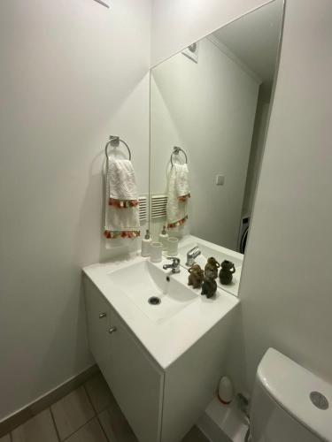 a white bathroom with a sink and a mirror at Exponor 2026 DEPARTAMENTO 1 DORMITORIO in Antofagasta