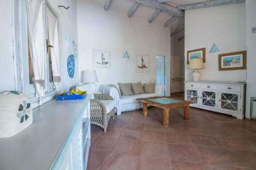 a living room with a couch and a table at GuestHost - Sea View Flat with Veranda and Pool in Liscia di Vacca