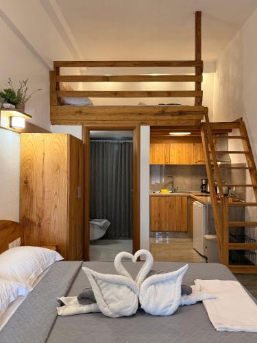 two swans sitting on a bed in a bedroom at Pinelopi’s House in Porto Koufo