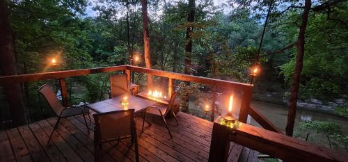 a deck with a table and chairs and candles on it at Cliffside at Piney Falls - Creek Access - Sweeping Views in Boswell